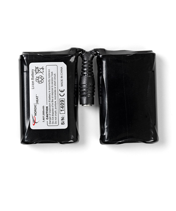 Dvi juodos ličio jonų baterijos su etiketėmis, skirtos šildomiems drabužiams, specifikacijos: 7.4V, 3000 mAh. Kištuko jungtis gale, pagaminta Kinijoje. Įspėjimas: Neardykite ir nedeginkite.