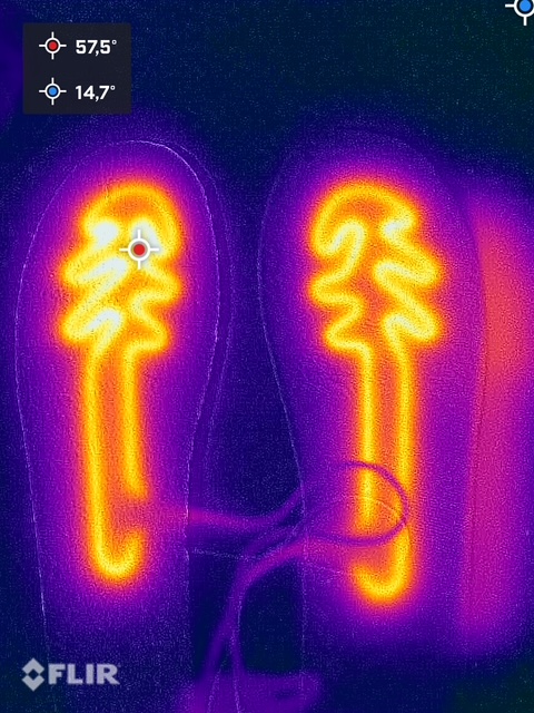 Termovizorinė nuotrauka rodo vidpadžius su šildymo funkcija, temperatūros matuojamos 57,5°C ir 14,7°C, šiltos-šaltos spalvų skalėje. Flir logotipas matomas apačioje kairėje.
