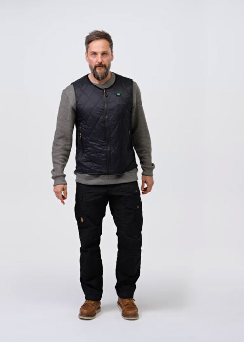 A man wearing a black quilted vest stands in front of a neutral background. The design of the vest indicates that it is from the NordicHeat warmwear collection.