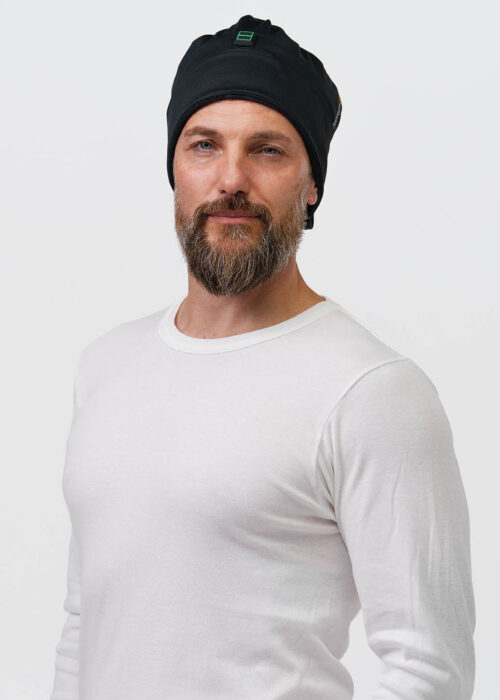 One person wears a black beanie with the NordicHeats logo, wearing a white sweater, promoting comfort and warmth, ideal for an active lifestyle.