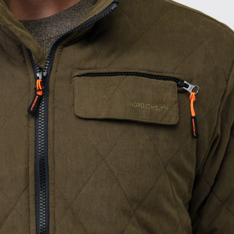 Ruda dygsniuota striukė su užtrauktukais ir oranžinėmis virvelėmis. "NORDICHEAT" logotipas matomas ant krūtinės kišenės atvarto. Striukė dėvima patalpoje ant megztinio.