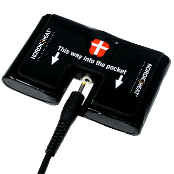 A black battery pack for NordicHeat warm clothing with plug is marked with instructions: "This way into the pocket." Danish flag is visible on the pack.